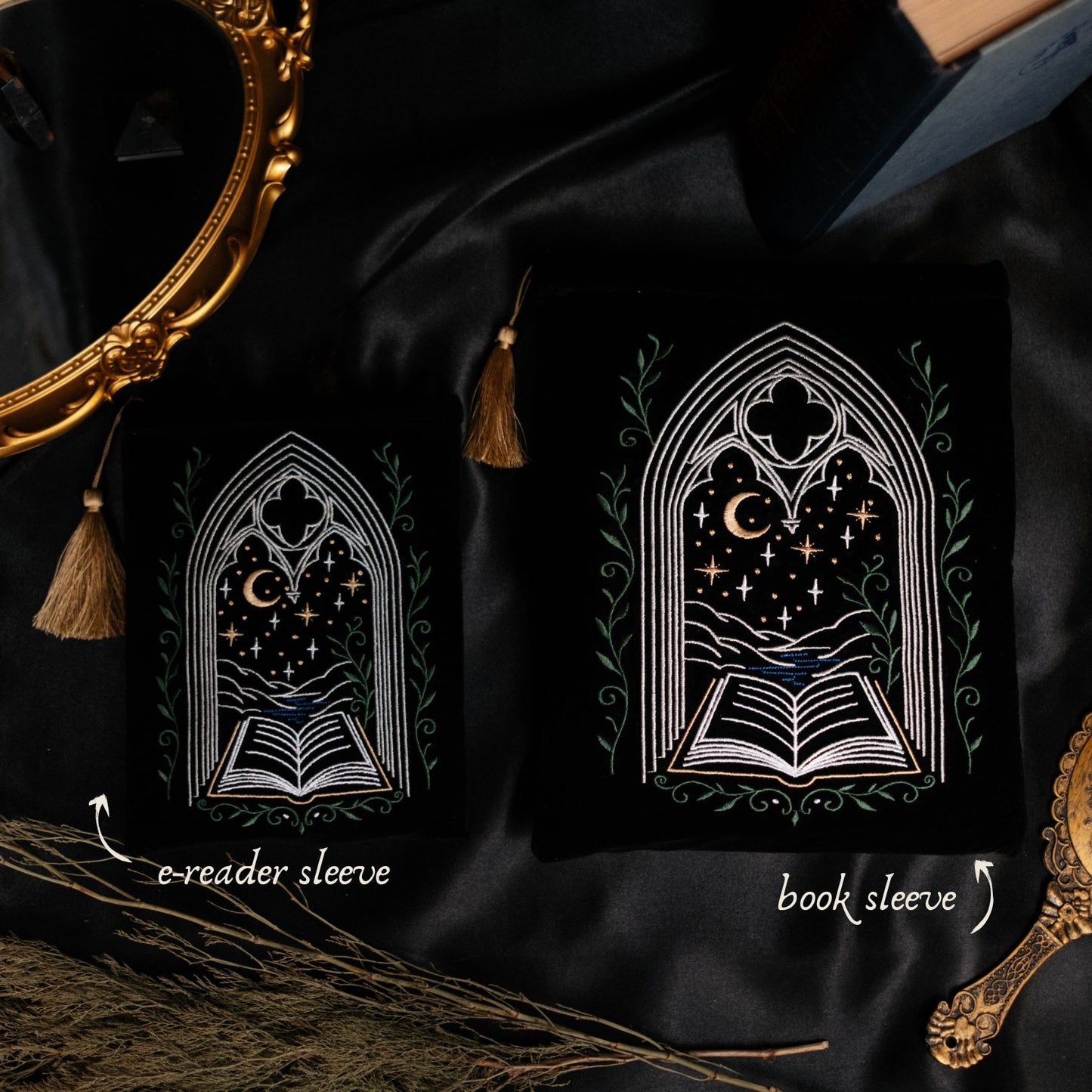 Two black pouches with gothic window designs on a dark fabric background.