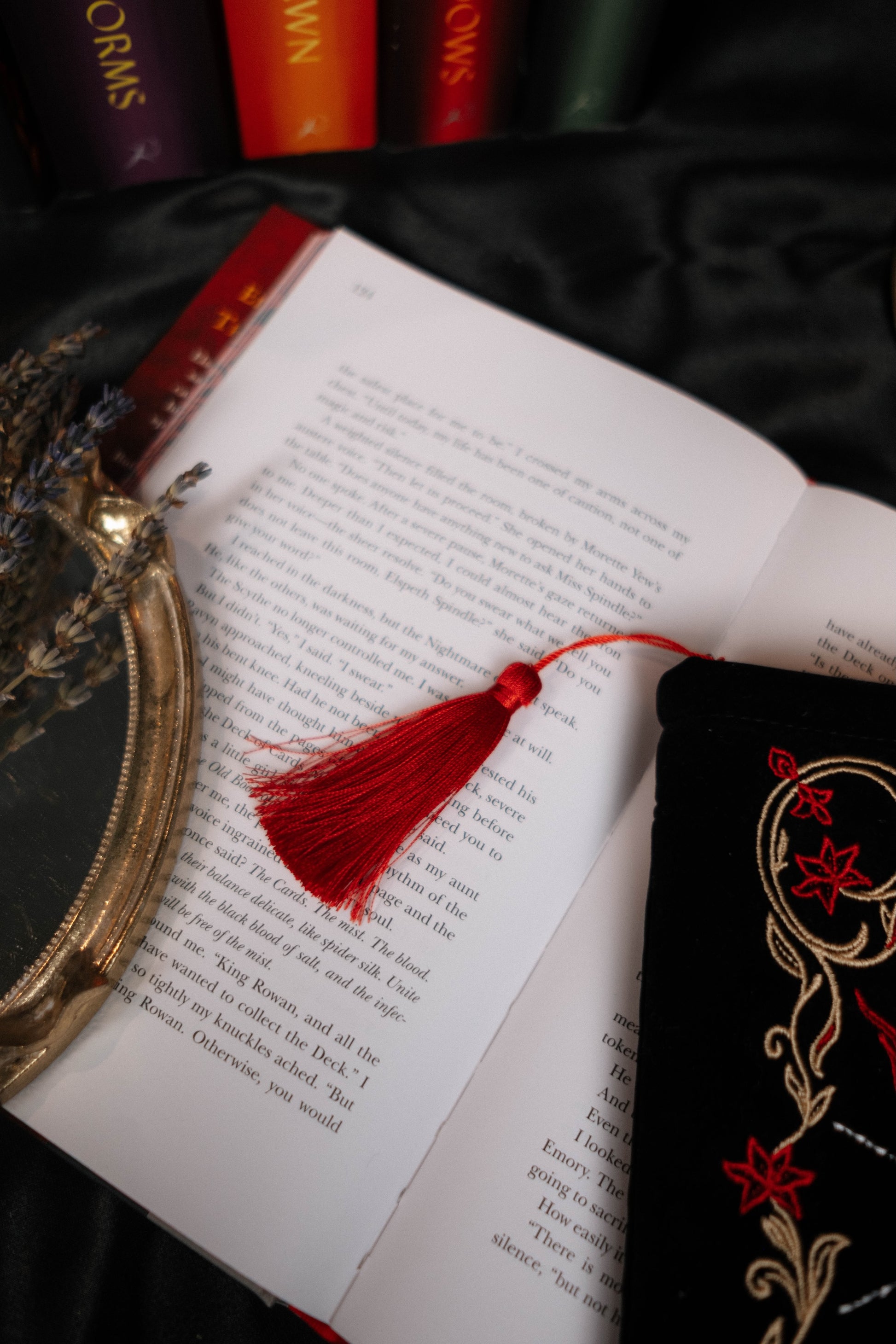 Open book with a red tassel on a dark fabric background