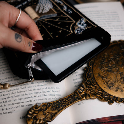 Black kindle pouch with decorative elements on an open book