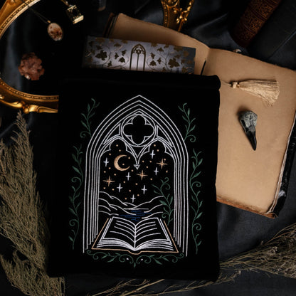 Decorative book sleeve with a gothic design on a dark fabric background