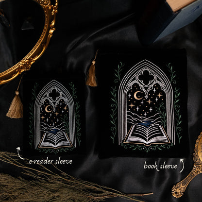 Two black pouches with gothic window designs on a dark fabric background.